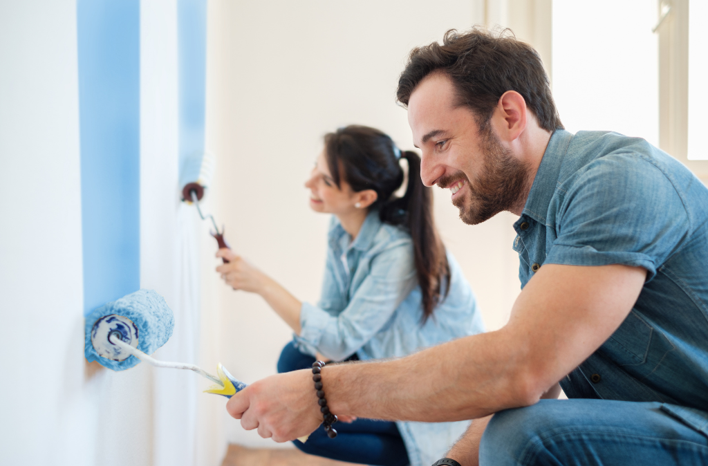Happy couple painting a wall together during a DIY home improvement