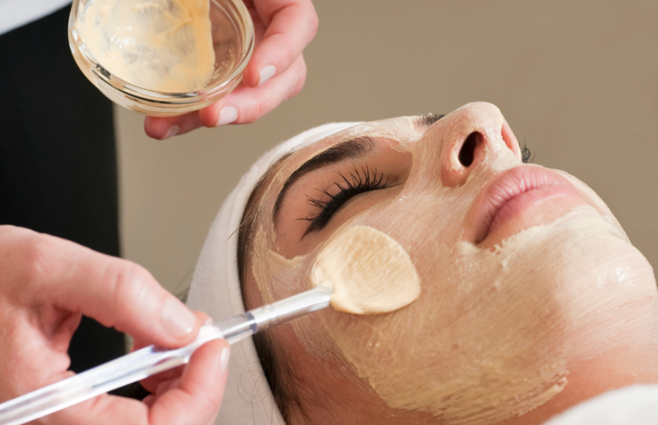 The image depicts a woman receiving a facial treatment