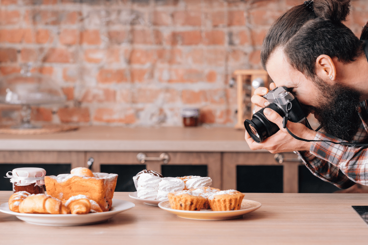 Food Photographer taking a close-up shot of a cupcake and pastry.