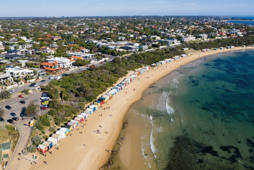 Drone photos of Brighton Bathing Boxes located in Melbourne, Australia. This well-known Melbourne beach spot is ideal for capturing the feel of an Australian summer. These colourful beach huts are close to the city, with views of the skyline in some photo