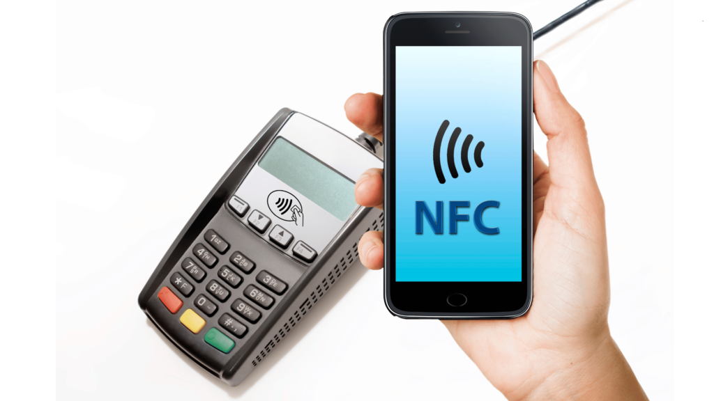 Generic smart phone held by a female hand onto a pos terminal machine with signs of contactless near field communication (nfc)