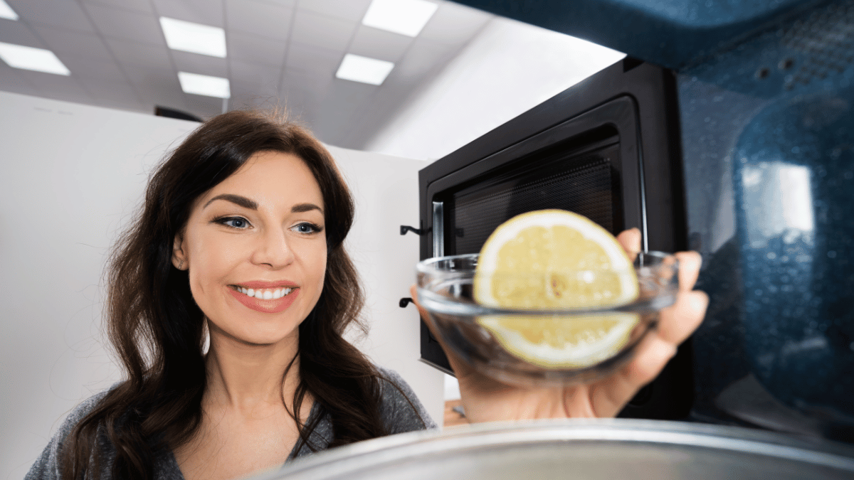 Woman Cleaning Microwave With Lemon