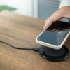 Charging iPhone battery with wireless charging device in the table.