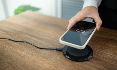 Charging iPhone battery with wireless charging device in the table.