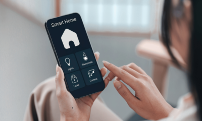 Person using a smart home app on a smartphone to manage lights, thermostat and security features in a modern Australian home.