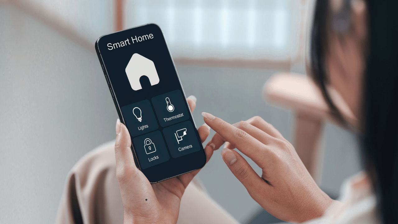 Person using a smart home app on a smartphone to manage lights, thermostat and security features in a modern Australian home.