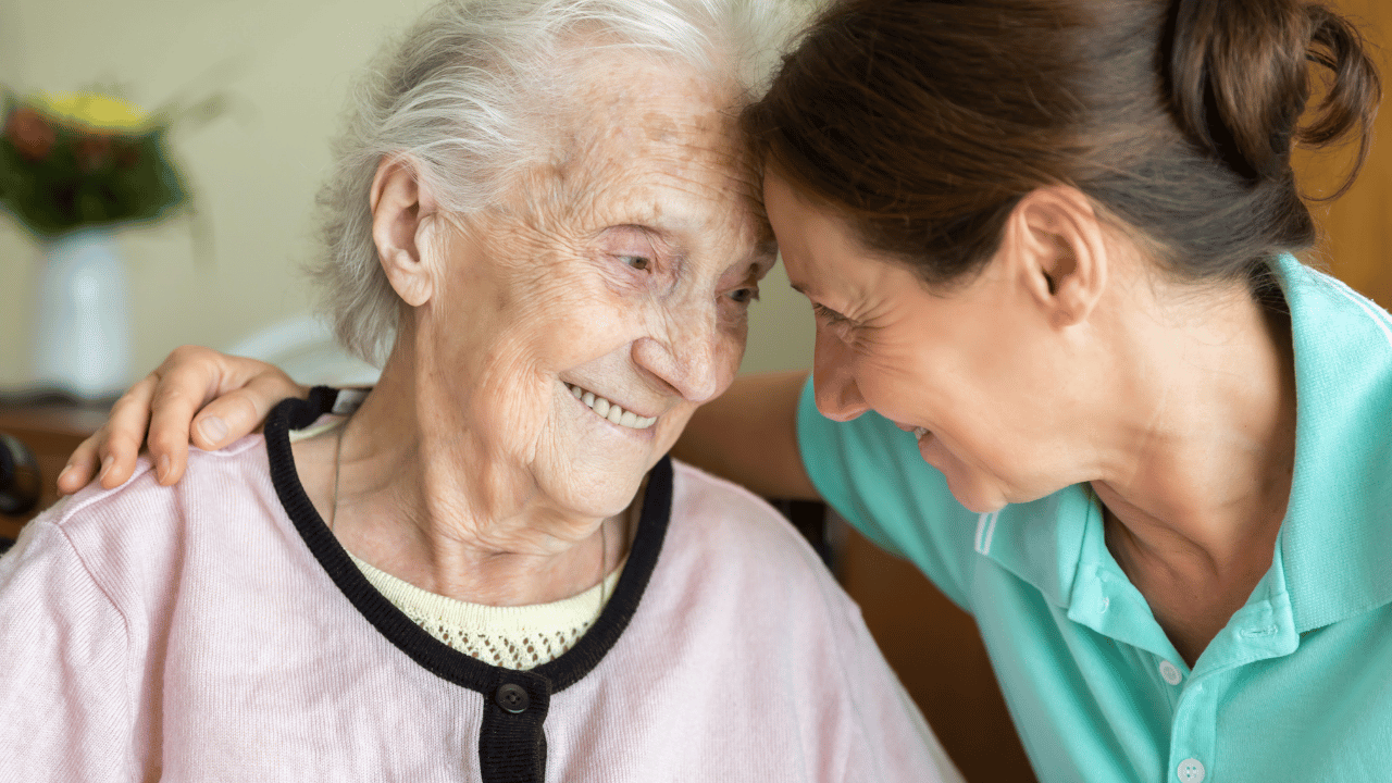 “Senior woman receiving support from a home caregiver, representing dementia care and daily living assistance.