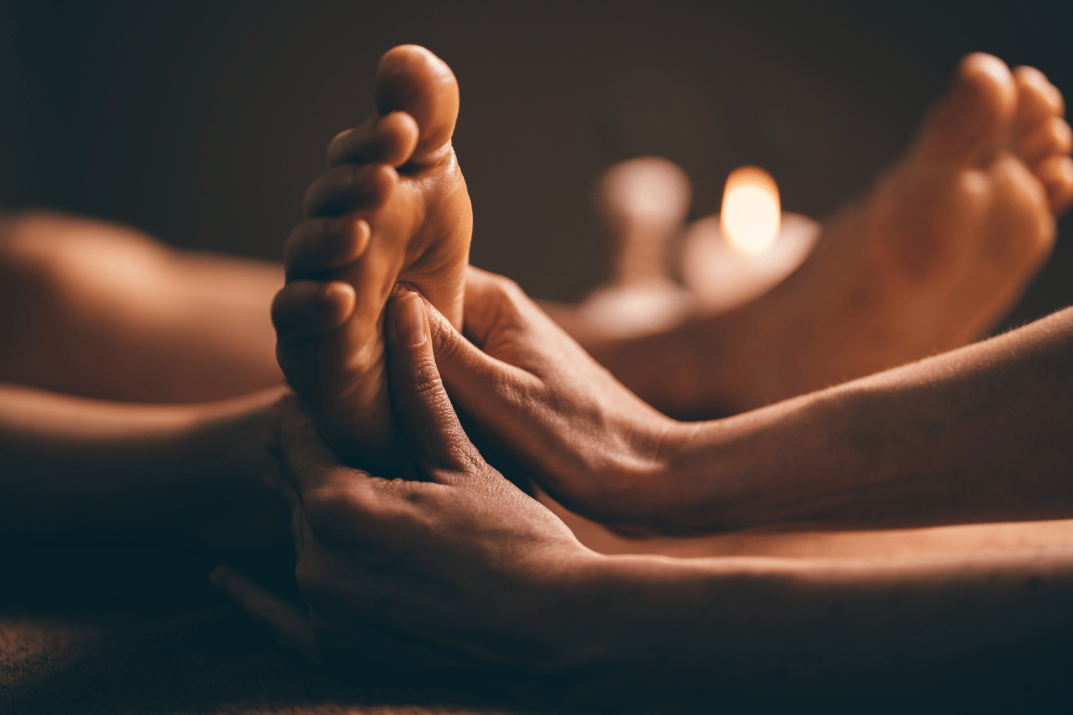 Person pressing the Kidney 1 acupressure point on the sole of the foot to support relaxation before sleep