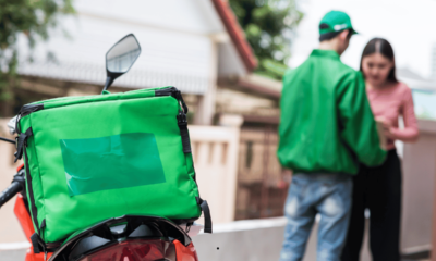 Food delivery driver delivering a meal to a customer — symbolising changes after Menulog closing down in Australia