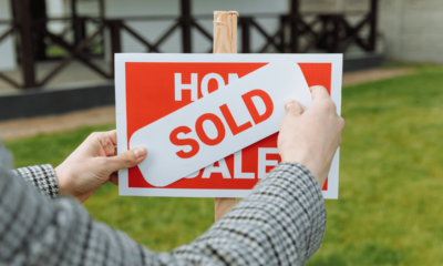 SOLD sticker being placed on a home for sale sign, reflecting rising Adelaide property prices.