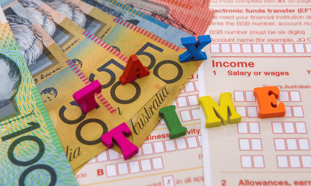 Australian tax forms and banknotes with ‘tax time’ letters, representing small business tax deductions and instant asset write-off.