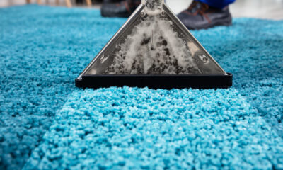 Professional steam carpet cleaning removing deep dirt from a blue carpet