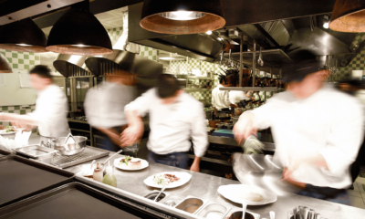 Busy restaurant kitchen during service showing labour intensity and operational pressure