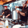 Chefs working in a busy commercial restaurant kitchen during dinner service in Australia