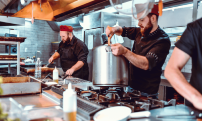 Chefs working in a busy commercial restaurant kitchen during dinner service in Australia
