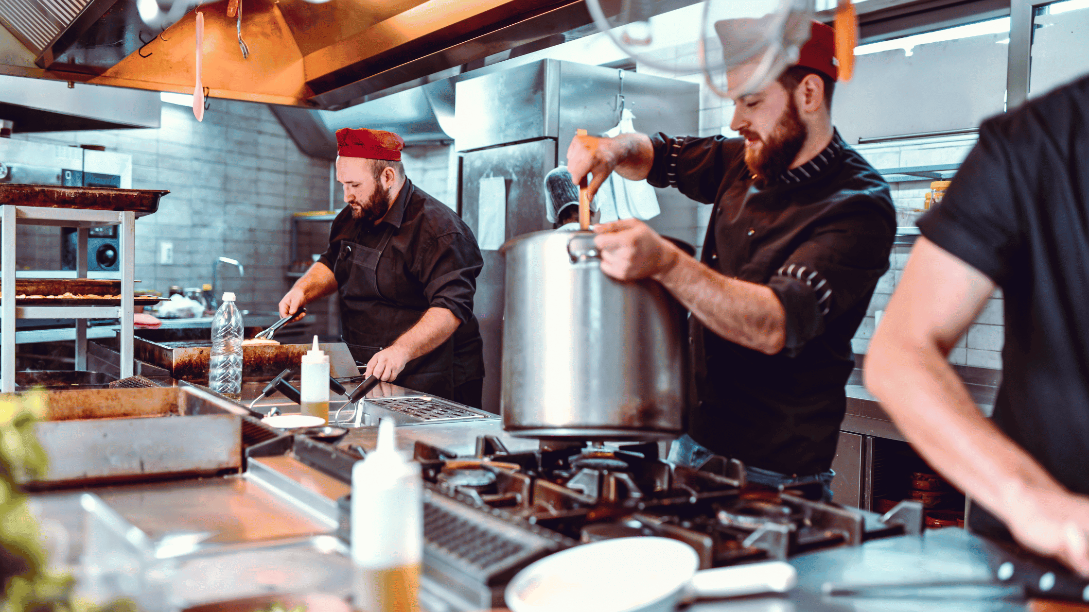 Chefs working in a busy commercial restaurant kitchen during dinner service in Australia