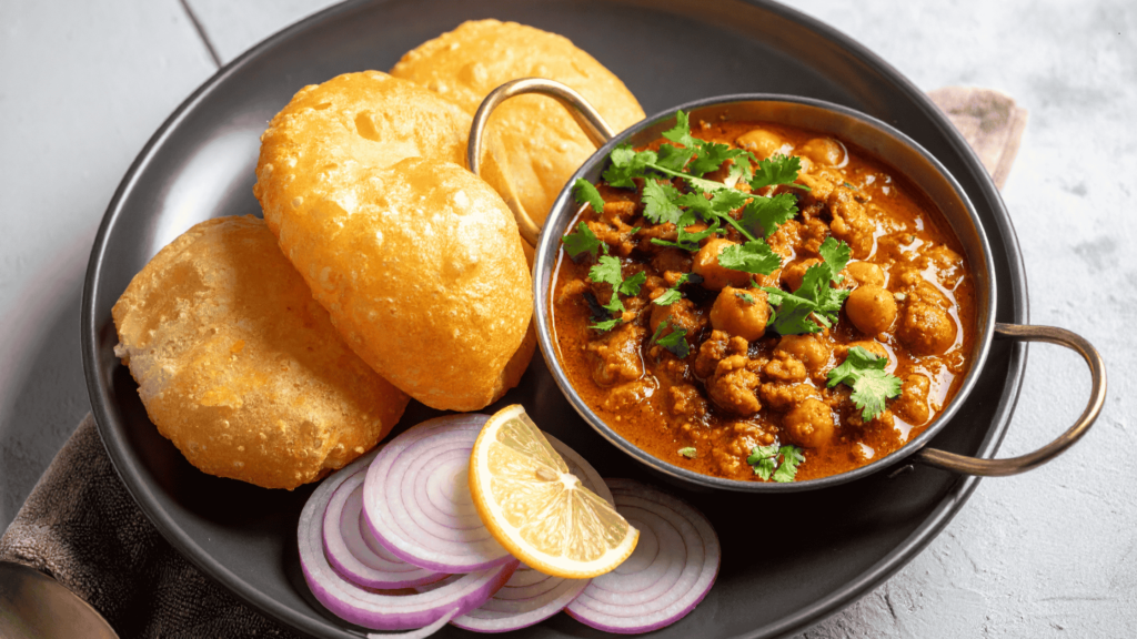 Chole bhature with chickpea curry served with fried bread and onions