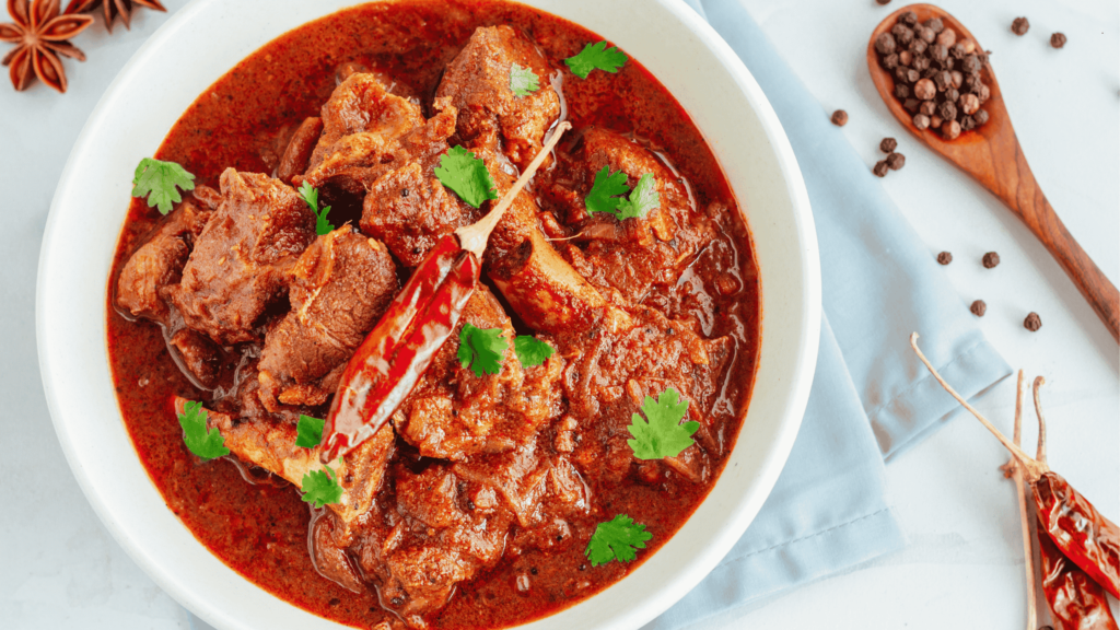 Spicy vindaloo curry with tender meat in rich red sauce and chillies