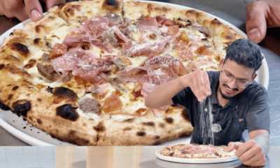 Wood-fired Mandi Mandi pizza from Pizzeria Trieste in Port Lincoln, with a chef seasoning a pizza in the foreground.