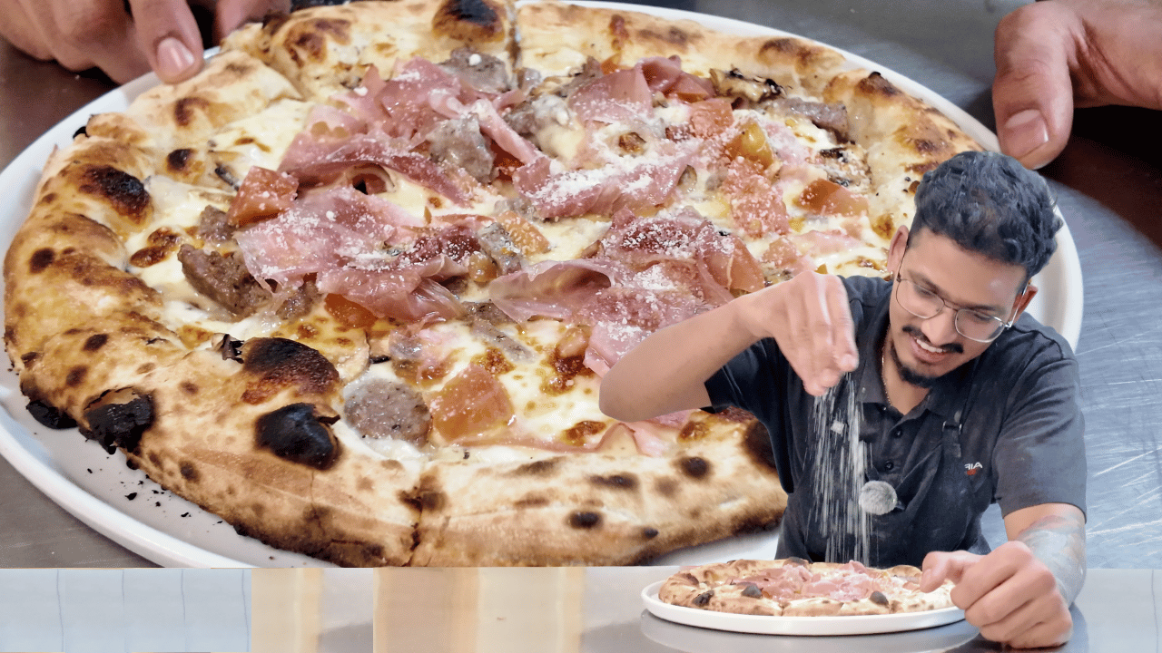 Wood-fired Mandi Mandi pizza from Pizzeria Trieste in Port Lincoln, with a chef seasoning a pizza in the foreground.